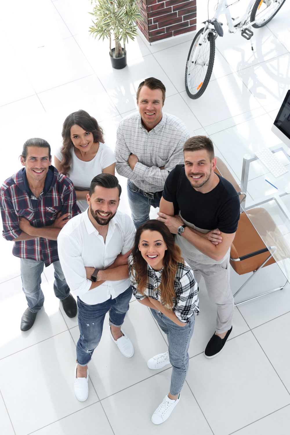 view the top. creative business team standing near the desktop and looking up